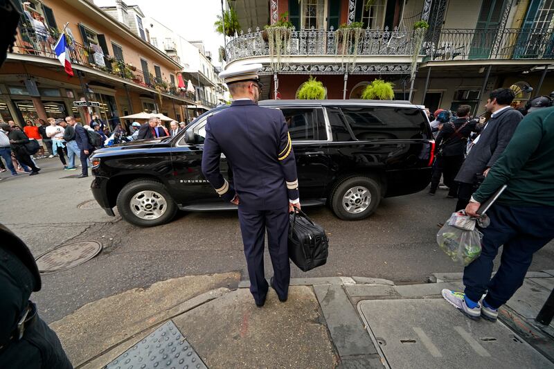 A French military aide stands by as Mr and Ms Macron walk through the French Quarter. AP