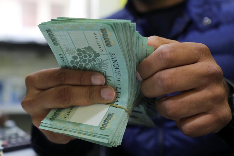 A man counts Lebanese pound banknotes at a currency exchange shop in Beirut, Lebanon March 2, 2021. REUTERS/Mohamed Azakir