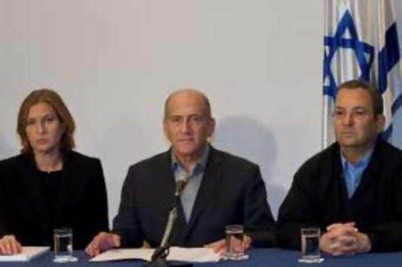 Israel's Prime Minister Ehud Olmert, center, talks as Defense Minister Ehud Barak, right, and Foreign Minister Tzipi Livni listen during a press conference at the Prime Minister's office in Tel Aviv, Saturday, Dec. 27, 2008. Israeli warplanes retaliating for rocket fire from the Gaza Strip pounded dozens of security compounds across the Hamas-ruled territory in unprecedented waves of air strikes Saturday, killing more than 200 people and wounding nearly 400 in the single bloodiest day of fighting in years. (AP Photo/Moti Milrod) *** Local Caption ***  JRL173_APTOPIX_MIDEAST_ISRAEL_PALESTINIANS.jpg