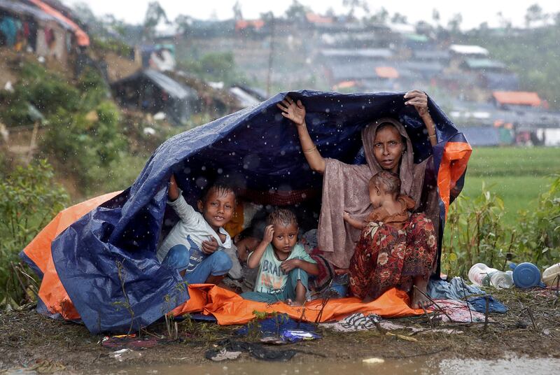 Rohingya refugees take shelter from the rain in a camp in Cox's Bazar, Bangladesh. Cathal McNaughton / Reuters