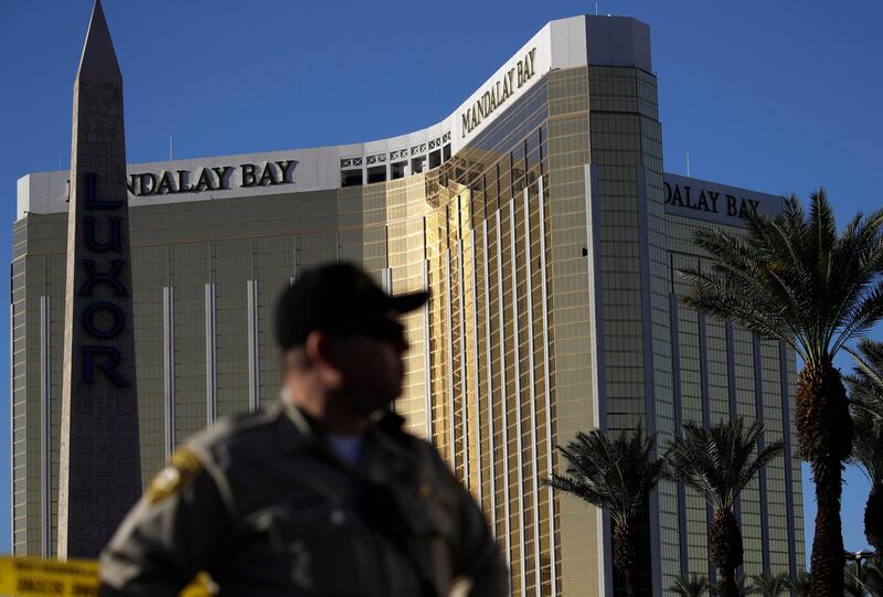 A Las Vegas police officer stands by a blocked off area near the Mandalay Bay casino, Tuesday, Oct. 3, 2017, in Las Vegas. Authorities said Stephen Craig Paddock broke windows on the casino and began firing with a cache of weapons, killing dozens and injuring hundreds at the festival. (AP Photo/John Locher)