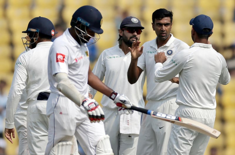 India's Ravichandran Ashwin, second right, celebrates with teammates the dismissal of Sri Lanka's Lahiru Thirimanne, second left, during the first day of their second test cricket match in Nagpur, India, Friday, Nov. 24, 2017. (AP Photo/Rajanish Kakade)