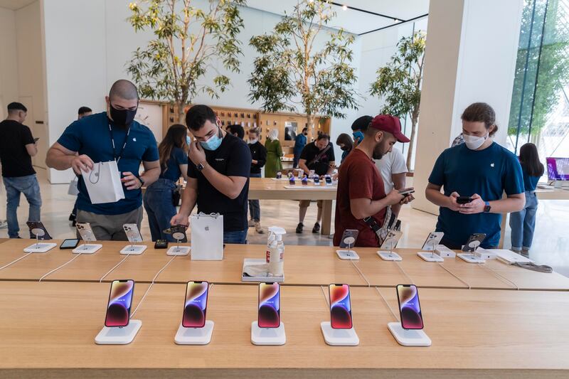 iPhone 14 units are seen at the Apple Store in The Dubai Mall. The company on Thursday reported that net profit for its fiscal third quarter rose 2.3 per cent annually to more than $19.8 billion, despite the company reporting a yearly drop in total sales. Antonie Robertson / The National