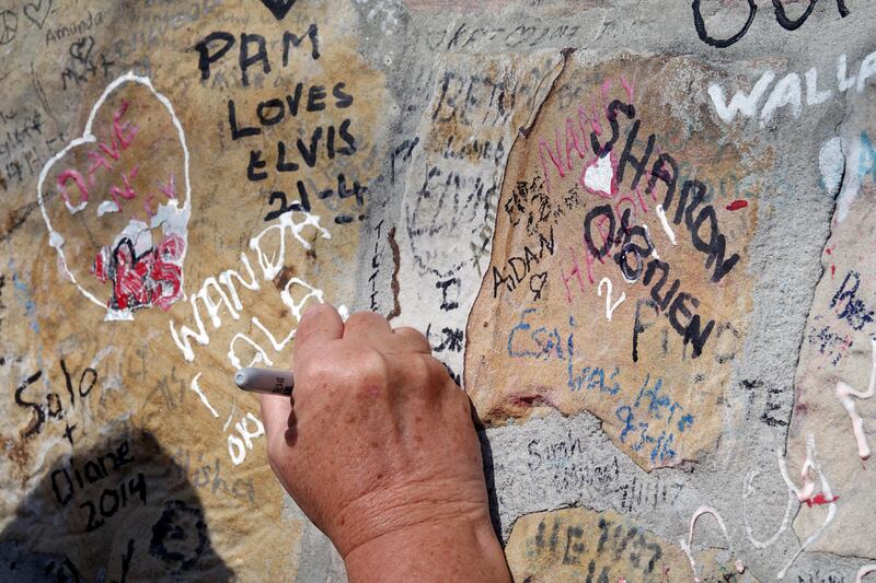 Fans continue to leave love notes to Elvis on the wall of Graceland as mourners gather to commemorate the 40th anniversary of the death of singer Elvis Presley at his former home of Graceland, in Memphis, Tennessee. Karen Pulfer Focht / Reuters