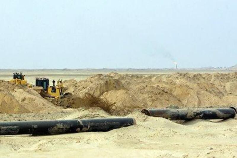 Pipes are put in place as the land is cleared at Iraq's Majnoon oilfield, where the government is blaming Shell for production shortfalls. Ali Al Saadi / AFP