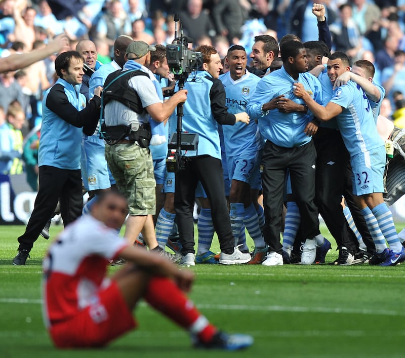 Manchester City's players and supporters celebrate the win over QPR. AFP