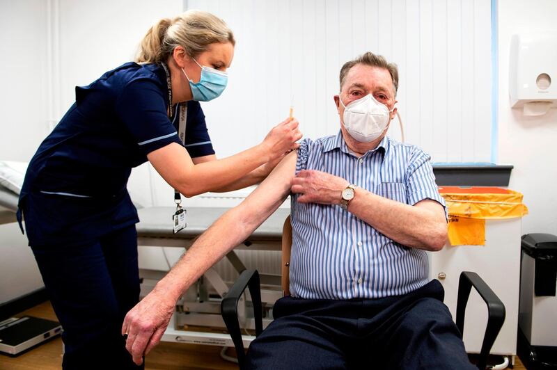 Advanced nurse practitioner Justine Williams (L) prepares to administer a dose of the AstraZeneca/Oxford Covid-19 vaccine to 82-year-old James Shaw, the first person in Scotland to receive the vaccination, at the Lochee Health Centre in Dundee on January 4, 2021. / AFP / POOL / Andy Buchanan
