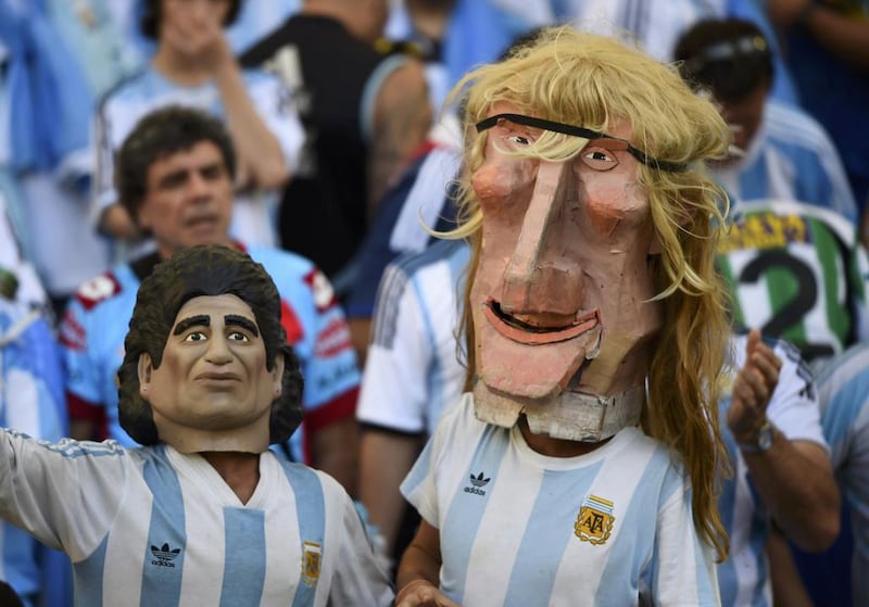 A pair of Argentine fans, wearing masks of retired soccer players Diego Maradona and Claudio Caniggia, right, wait for the start of the final. Dylan Martinez / Reuters