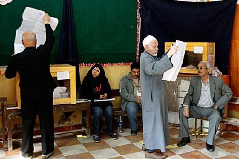 A voter inspects a list of candidates before voting in the Shubra neighbourhood of Cairo yesterday.