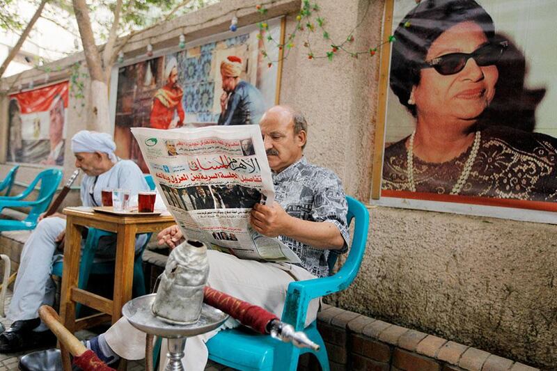 An Egyptian man reads the daily Al-Ahram newspaper at a coffee shop in Cairo, Egypt. AP