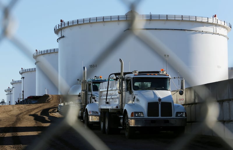FILE PHOTO: Dump trucks are parked near crude oil tanks at Kinder Morgan's North 40 terminal expansion construction project in Sherwood Park, near Edmonton, Alberta, Canada November 13, 2016.  REUTERS/Chris Helgren/File Photo
