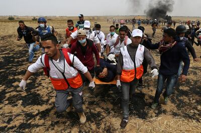 A wounded Palestinian is evacuated during clashes with Israeli troops at a protest where Palestinians demand the right to return to their homeland, at the Israel-Gaza border in the southern Gaza Strip, April 20, 2018. REUTERS/Ibraheem Abu Mustafa