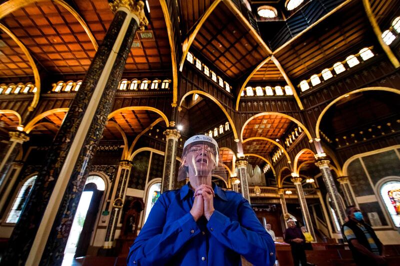 A woman wearing a face shield prays at the Basilica de los Angeles in Cartago, Costa Rica.  AFP