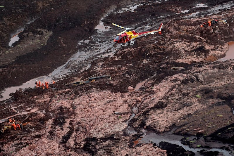 Aerial view showing firemen looking for people in heavy machinery and a locomotive after the collapse of a dam which belonged to Brazil's giant mining company Vale. AFP