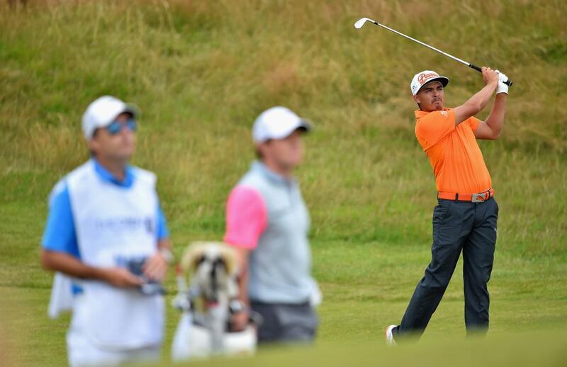 Rickie Fowler hits his second shot on the 11th hole as Rory McIlroy and caddie JP Fitzgerald look on during the final round of the British Open on Sunday. Stuart Franklin / Getty Images