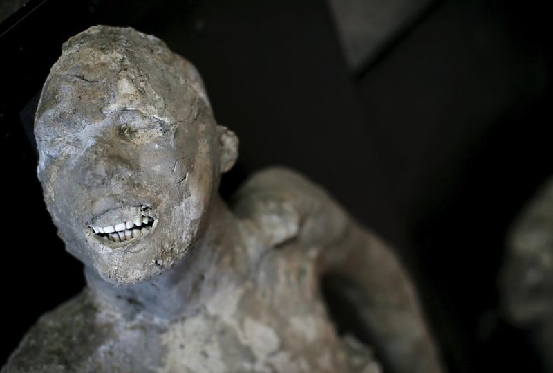 The plaster cast of a Pompeii victim lies in a frescoed room.   Alessandro Bianchi / Reuters