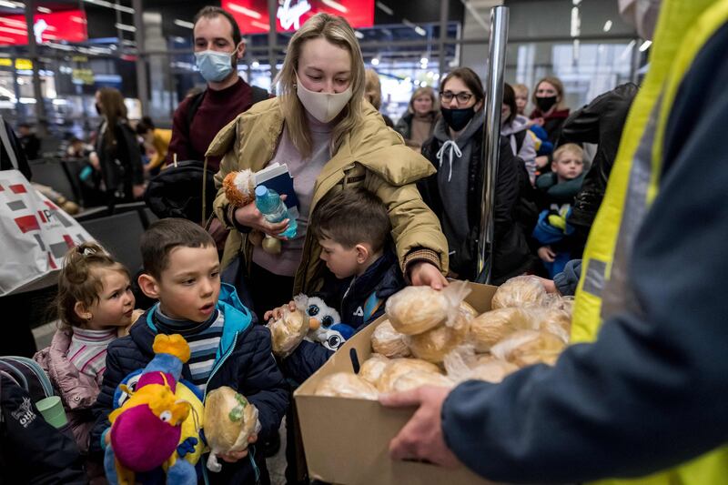 Ukrainian refugees take sandwiches at Krakow Airport before boarding a plane to Zurich, chartered by a Swiss millionaire. AFP