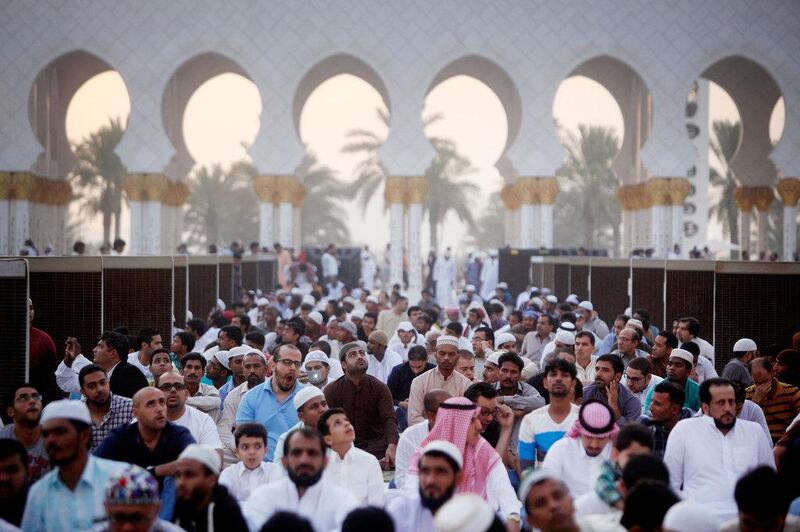 Men wait for the start of Eid prayers. Christopher Pike / The National