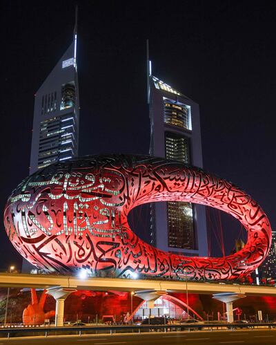 This picture taken on February 6, 2021 shows a view of the Museum of the Future in Dubai, lit red ahead of the UAE's "Al-Amal" -- Arabic for "Hope" -- probe's arrival in Mars' orbit, in what is considered the most critical part of the journey to the Red Planet. The unmanned probe -- named "Al-Amal" -- Arabic for "Hope" -- blasted off from Japan last year, marking the next step in the United Arab Emirates' ambitious space programme.  / AFP / Giuseppe CACACE
