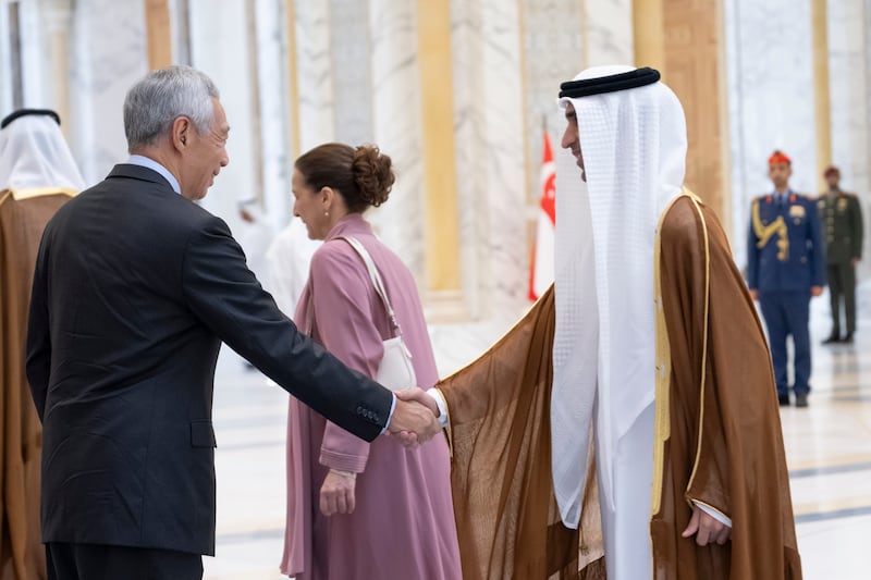 Dr Thani Al Zeyoudi, Minister of State for Foreign Trade, greets Mr Lee during the official reception at Qasr Al Watan. Hamad Al Kaabi / UAE Presidential Court
