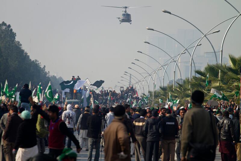 A Pakistani army helicopter monitors supporters of Pakistan Sunni Muslim cleric Tahir-ul-Qadri holding an anti-government rally in Islamabad, Pakistan, Tuesday, Jan. 15, 2013. Thousands of anti-government protesters are rallying in the streets of Pakistani capital for second day despite early-morning clashes with police who fired off shots and tear gas to disperse the crowd. (AP Photo/Anjum Naveed) *** Local Caption ***  Pakistan.JPEG-0ded3.jpg