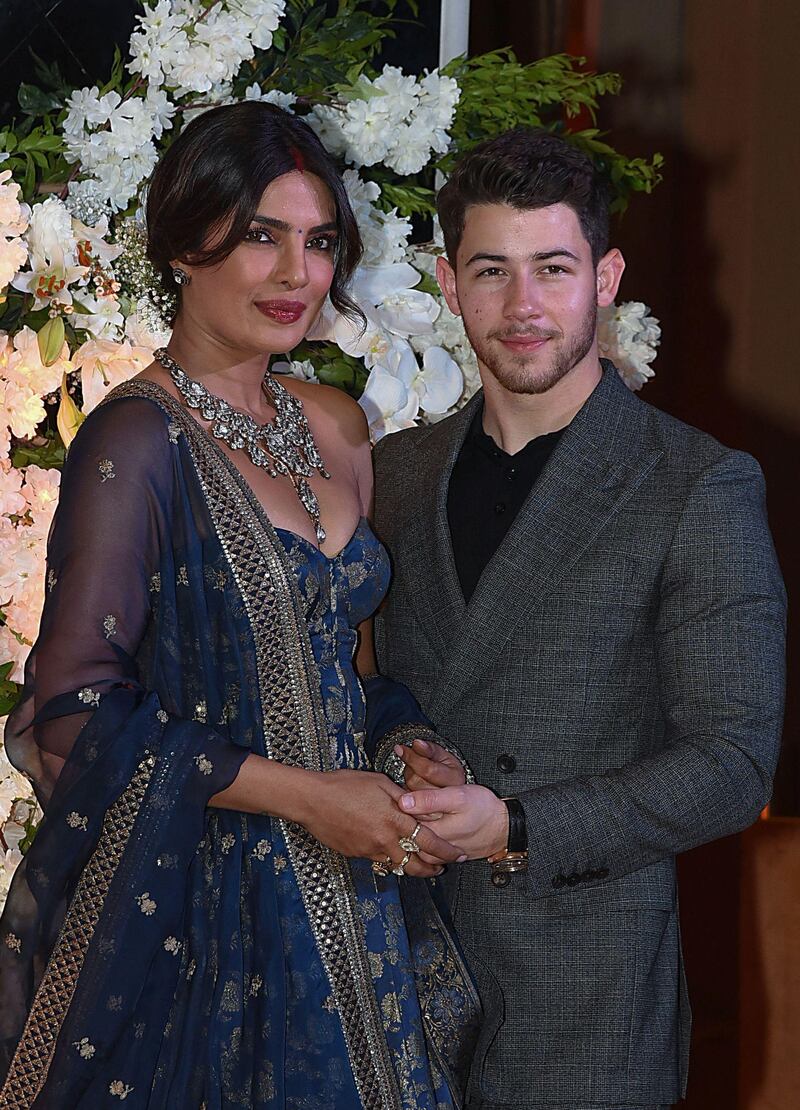 Indian Bollywood actress Priyanka Chopra (L) and US musician Nick Jonas, who were recently married, pose for a picture during a reception in Mumbai / AFP / Sujit Jaiswal