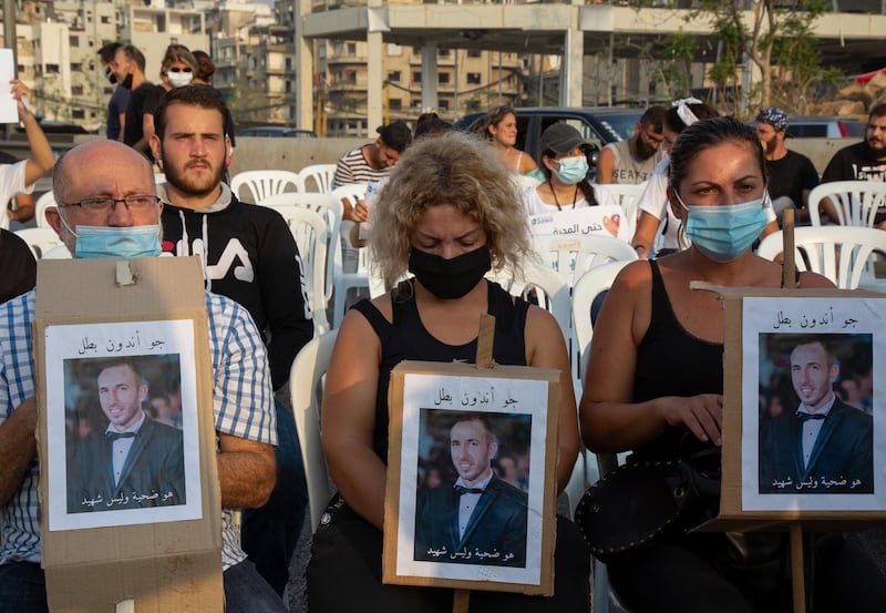 Families of Beirut port explosion victims carry their pictures during a minute of silence and prayer to mark one month of Beirut port explosion. EPA