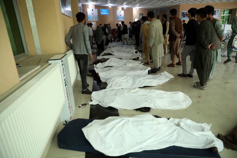 Afghan men try to identify bodies at a hospital after a deadly bomb explosion near a school west of Kabul.  AP