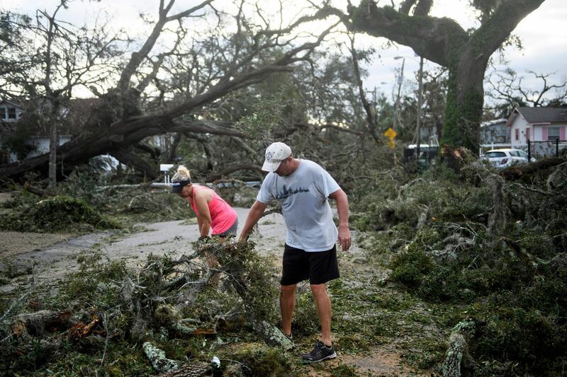 Residents clear a road of fallen trees in the aftermath of Hurricane Michael on October 11, 2018 in Panama City, Florida. Residents of the Florida Panhandle woke to scenes of devastation Thursday after Michael tore a path through the coastal region as a powerful hurricane that killed at least two people. / AFP / Brendan Smialowski
