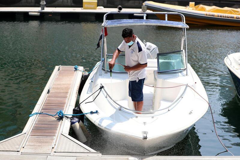 Dubai, United Arab Emirates - N/A. News. Coronavirus/Covid-19. A man at the marina hoses down a boat. Friday, September 11th, 2020. Dubai. Chris Whiteoak / The National
