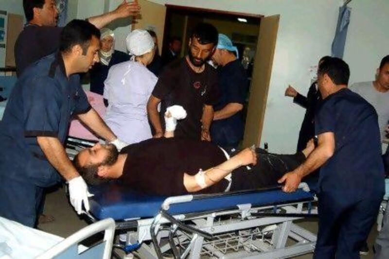 Turkish medics accompany a wounded Syrian man after he crossed the border at a hospital in Gaziantep, Turkey, yesterday.