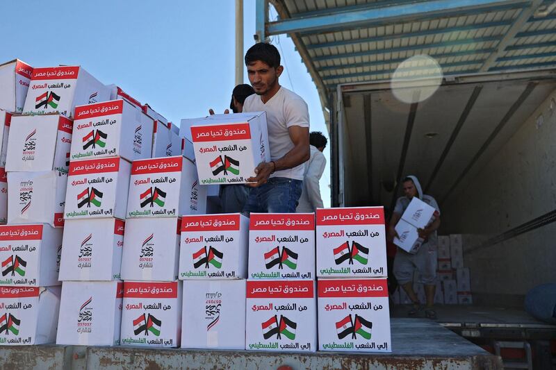 Palestinians unload aid at the Rafah border crossing. AFP