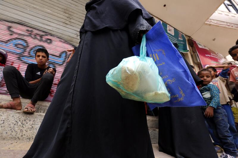 epa06874163 A displaced Yemeni, who fled home in the war-torn city of Hodeidah, receives free food rations provided by a charity in Sana'a, Yemen, 08 July 2018. According to reports, more than 17,350 households (over 121,000 Yemenis) have been displaced from the war-torn port city of Hodeidah after the fighting escalated there nearly a month ago between Houthi rebels and Yemeni forces backed by the Saudi-led military coalition.  EPA/YAHYA ARHAB