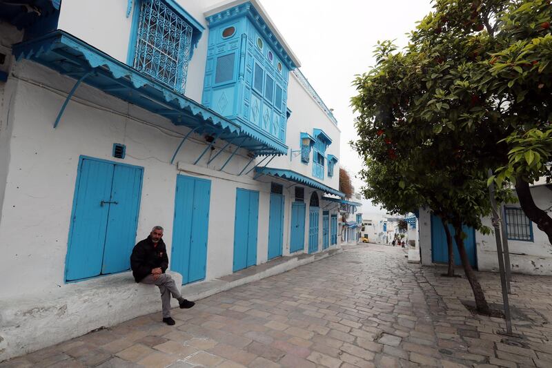 A man sits in the almost deserted street after the nation-wide quarantine was declared as part of measures to halt the spread of the novel coronavirus pandemic in Sidi Bou Said town, near Tunis, Tunisia.  EPA