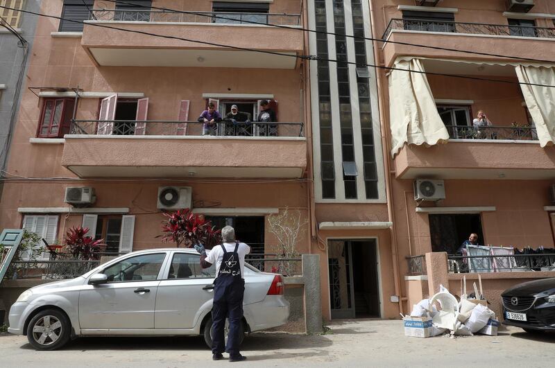 A volunteer speaks with people on a balcony in Beirut, Lebanon March 11, 2021. Picture taken March 11, 2021. REUTERS/Mohamed Azakir