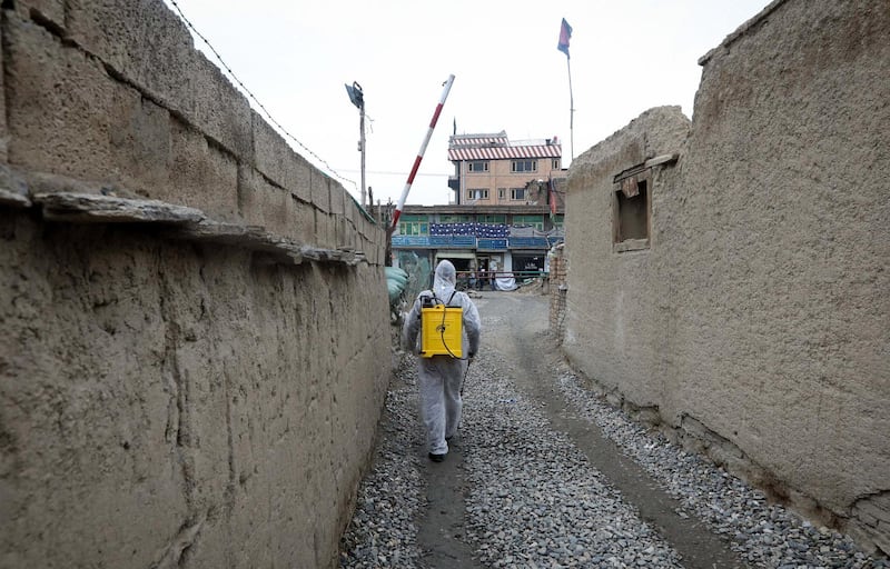 A worker disinfects area around a police station during a volunteered campaign of disinfecting areas and distributing face mask with gloves to fight against coronavirus in Kabul, Afghanistan, on March 23, 2020. According to the ministry of health of Afghanistan at least one person has died and 44 others are confirmed to be infected with coronavirus in the country.  EPA