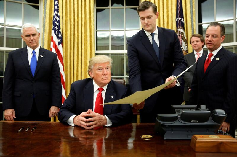 FILE PHOTO: White House Staff Secretary Rob Porter (2nd R) gives U.S. President Donald Trump, flanked by Vice President Mike Pence (L) and Chief of Staff Reince Priebus (R) the document to confirm Secretary of Defense James Mattis, Trump's first signing in the Oval Office in Washington, U.S., January 20, 2017. REUTERS/Jonathan Ernst/Files