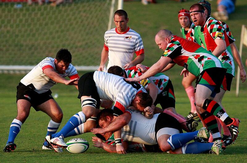 Abu Dhabi Harlequins, in red, ran in six tries on Friday to win 38-13 and see off the challenge of their city rivals, Abu Dhabi Saracens. Satish Kumar / The National