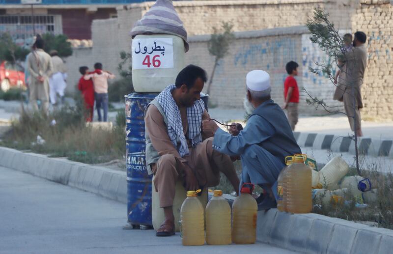 People sell petrol on a roadside in Kabul. EPA