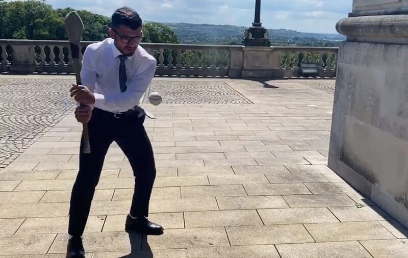 Abood Al Jumaili, who moved to Ireland as a child refugee from Iraq, displays his hurling skills at Stormont. Twitter @aboodaljumaili