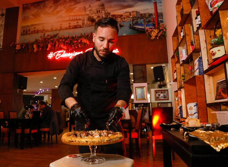 Ahmed Hergal, founder of Italian restaurant L'antica Pizzeria DaPietro, in Tunis, Tunisia, adds ingredients to his 999 Tunisian dinar (360 USD) pizza. Reuters