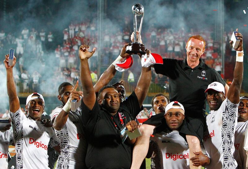 Fiji are crowned Sevens World Series Dubai Winners, while coach Ben Ryan (black shirt, red hair) celebrates with the trophy during the Dubai Rugby Sevens, at The Sevens, Dubai, on the 30th of November 2013. Credit: Jake Badger for The National *** Local Caption ***  JBadger3011_RugbySevensDay3_42.jpg