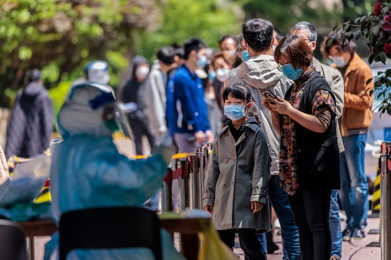 People line up for Covid-19 tests in a residential community under lockdown in Shanghai, China. EPA