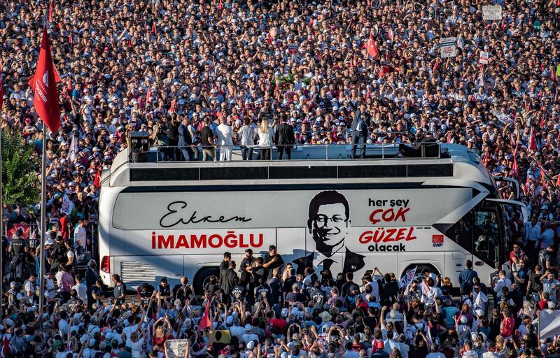 TOPSHOT - Istanbul's new mayor Ekrem Imamoglu addresses from atop a bus the crowd of supporters gathered outside Istanbul's town hall to attend his inauguration, on June 27, 2019, in Istanbul.

 / AFP / BULENT KILIC
