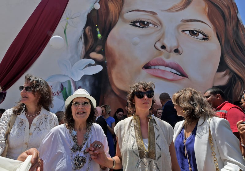 Italo-Tunisian actress Claudia Cardinale (2nd-L) walks through the city of La Goulette near the Tunisian capital on May 29, 2022, during an event honouring the actress in her birth city.  (Photo by FETHI BELAID  /  AFP)