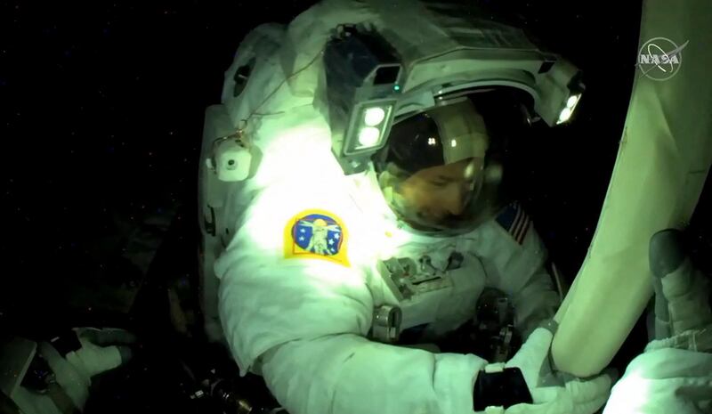 US astronaut Shane Kimbrough seen from ESA astronaut Thomas Pesquet's helmet camera, fixing bolts on the new solar panels. AFP