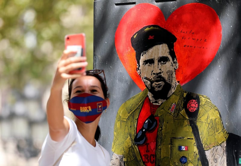 A woman takes a selfie with a mural of Lionel Messi dressed as Che Guevara. Reuters