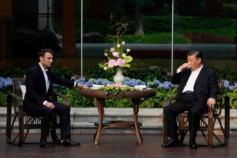 Chinese President Xi Jinping, right, and French President Emmanuel Macron during a tea ceremony at the Guandong province governor's residence on the third day of Mr Macron's visit to China. AFP