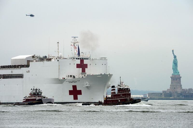TOPSHOT - The USNS Comfort medical ship moves up the Hudson River past the Statue of Liberty as it arrives on March 30, 2020 in New York.  A military hospital ship arrived in New York Monday as America's coronavirus epicenter prepares to fight the peak of the pandemic that has killed over 2,500 people across the US. The navy's 1,000-bed USNS Comfort entered a Manhattan pier around 10:45 am (1545 GMT). It will treat non-virus-related patients, helping to ease the burden of hospitals overwhelmed by the crisis. 
 / AFP / Bryan R. Smith
