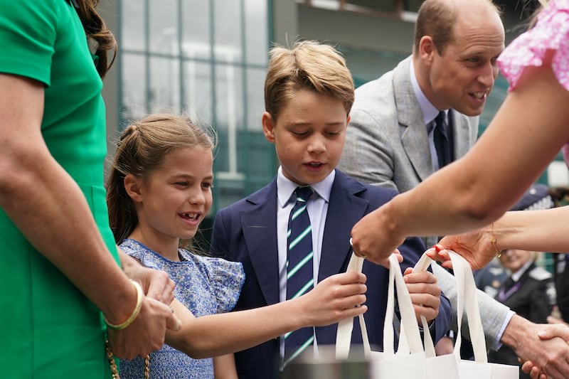 Princess Charlotte and Prince George receive gift bags before the men's singles final. AFP